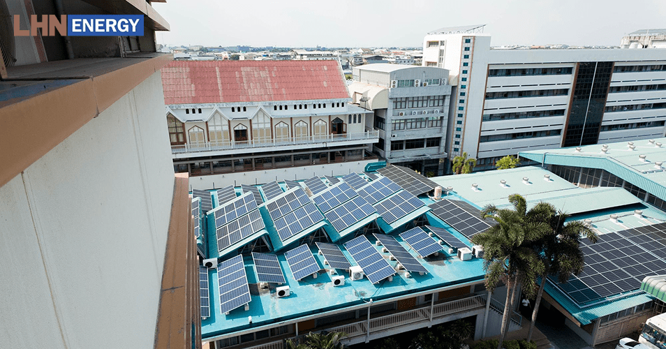 Commercial building rooftop with multiple solar panel arrays installed.