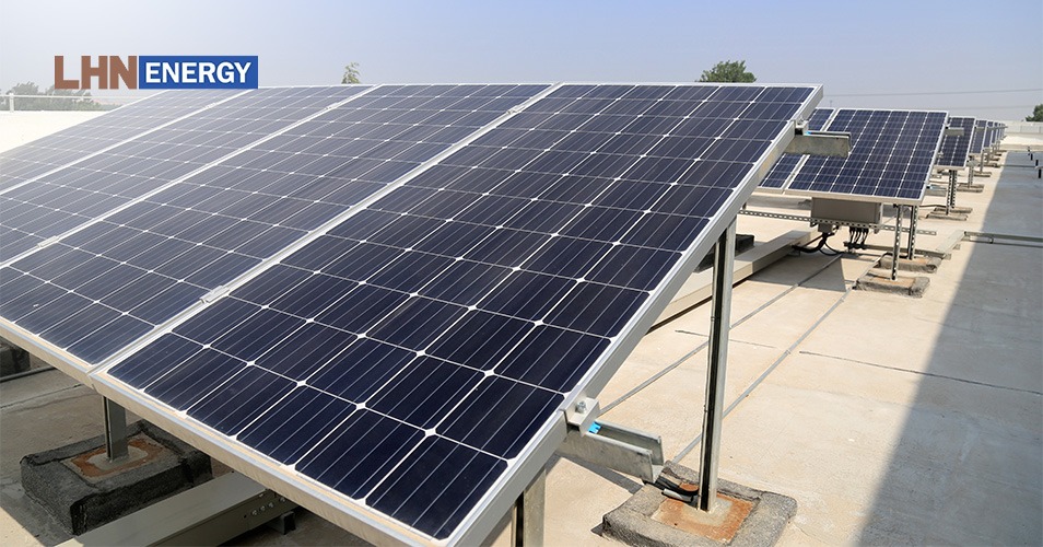 An overhead view of solar panel arrays on a rooftop.